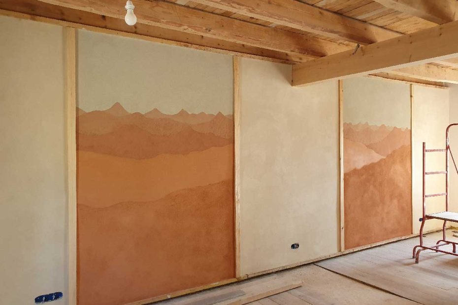 Fresque réalisé avec des enduits en terre de différentes couleur et représentant un paysage de montagne typique de Haute-Loire